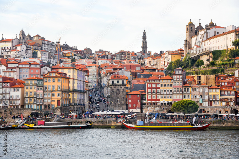 Porto, The Ribeira District, Portugal old town ribeira view with colorful houses, traditional facades, old multi-colored houses with red roof tiles, Douro river and boats.