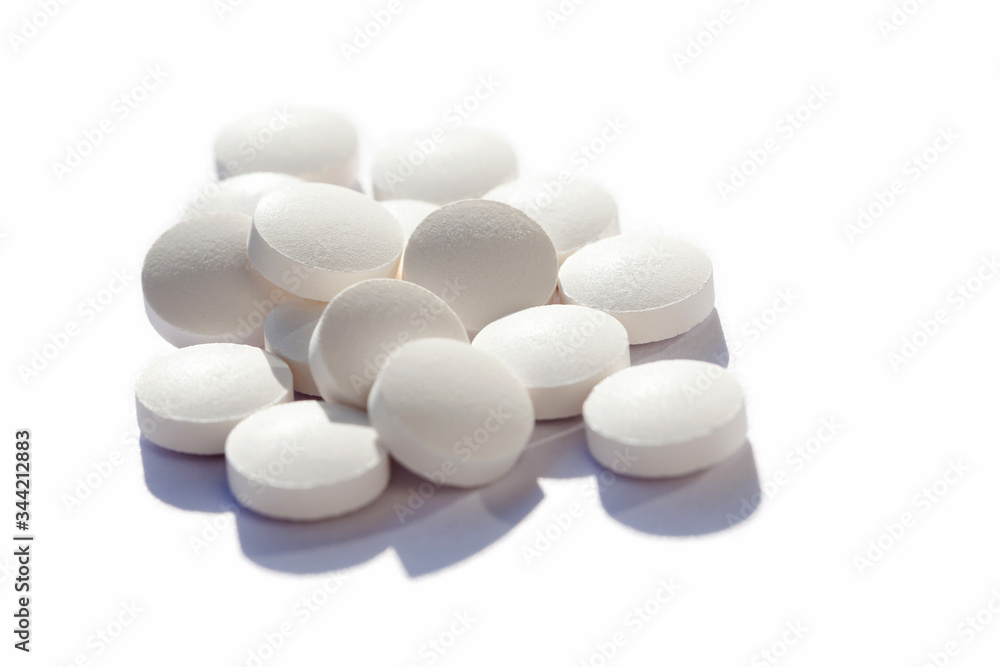 Many generic small round white pills, lots of little tablets on white background closeup. Simple group of little pills, medicine, medication and drugs concept. Hi key shot, high contrast, nobody Many generic small round white pills, lots of little tablets on white background closeup. Simple group of little pills, medicine, medication and drugs concept. Hi key shot, high contrast, nobody