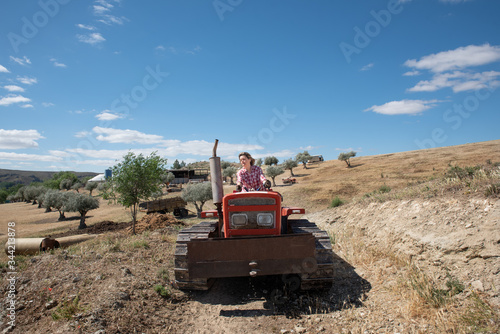 Farmer woman driving a tractor on her farm