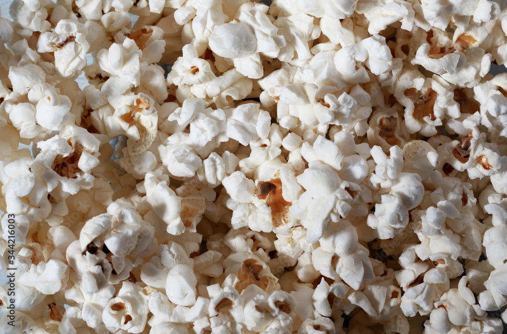 Flatlay of salted popcorn. Heap of homemade delicious popcorn. Snacks and food for a movie theater or cinema. Fastfood background. Strip texture Flatlay of salted popcorn. Heap of homemade delicious popcorn. Snacks and food for a movie theater or cinema. Fastfood background. Strip texture
