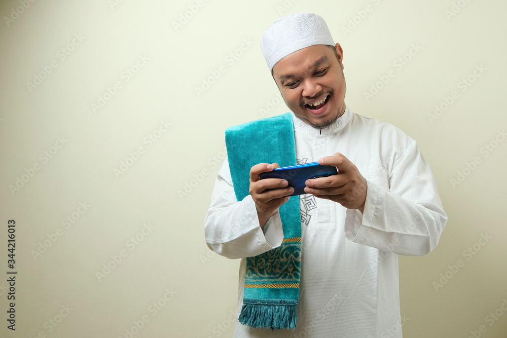 Fat Asian muslim man accessing his smart phone Fat Asian muslim man accessing his smart phone