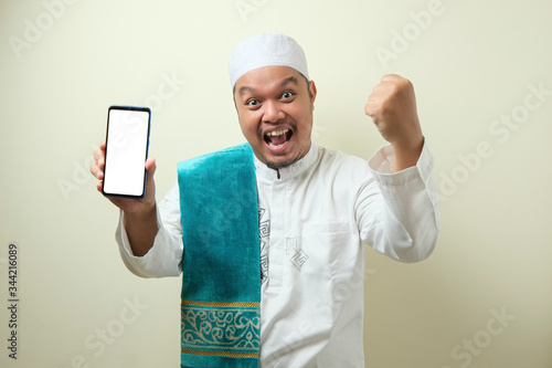 Fat Asian Muslim men looks surprised at the good news on phone