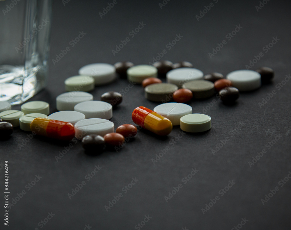 pills scattered on a black background