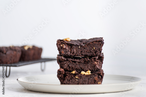 Front view of homemade chocolate brownie with white backdrop.