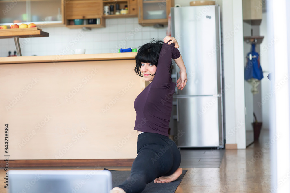 Junge sportliche Frau macht Fitness mit online Fitness zuhause Junge sportliche Frau macht Fitness mit online Fitness zuhause