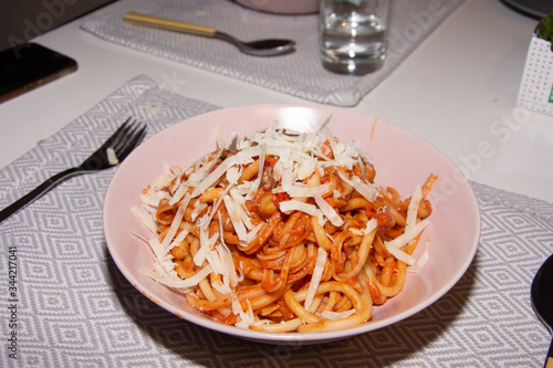 Essen Pasta mit Parmesan in Tomatensauce mitGabel und Löffel