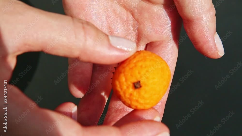 top view closeup on woman hands show small orange shaped marzipan candy top view closeup on woman hands show small orange shaped marzipan candy