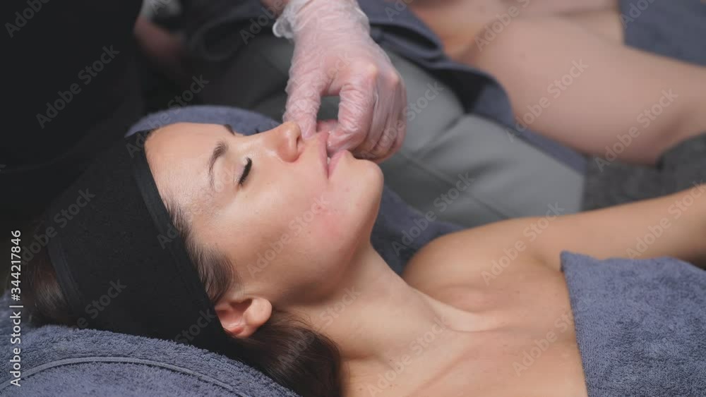 Cosmetologist makes buccal facial massage for an attractive woman. treatments for relaxation of facial muscles. close up. Cosmetologist makes buccal facial massage for an attractive woman. treatments for relaxation of facial muscles. close up.