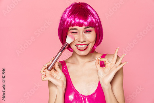 Image of young smiling girl gesturing ok sign and holding powder brush