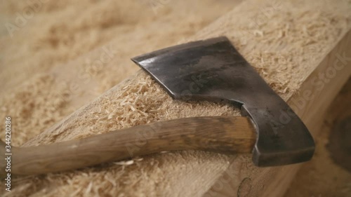 a sharp ax lies on a wooden bar and sawdust photo