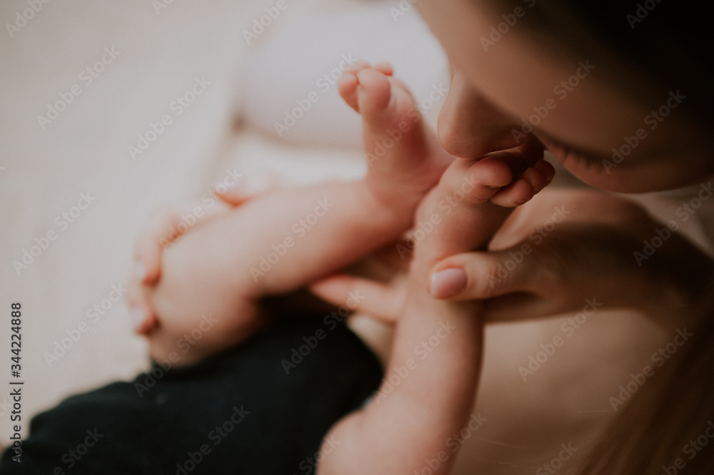 mother kisses the feet of baby 