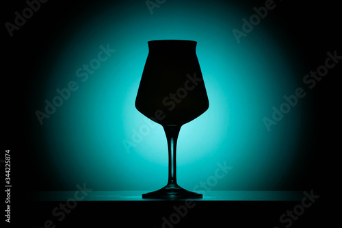 A teku style beer glass against a gradient blue to black background. photo