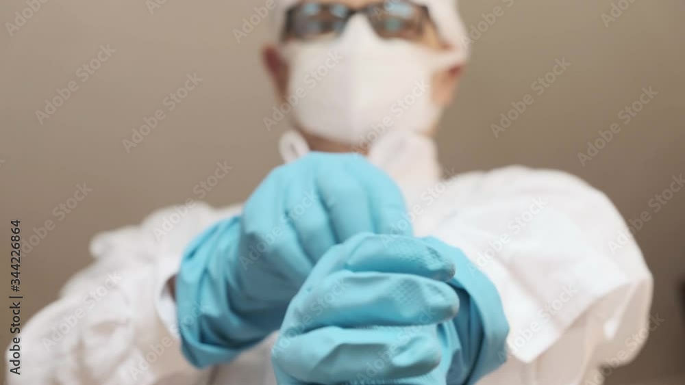 doctor with mask putting on rubber gloves. low point of view,
doctor with mask putting on rubber gloves. low point of view,