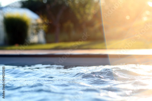 Detail on water in the pool with sunlight flare 