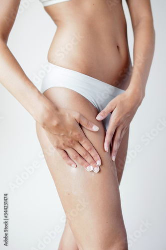 Taille, hanche, ventre et jambe d'une femme sur fond neutre