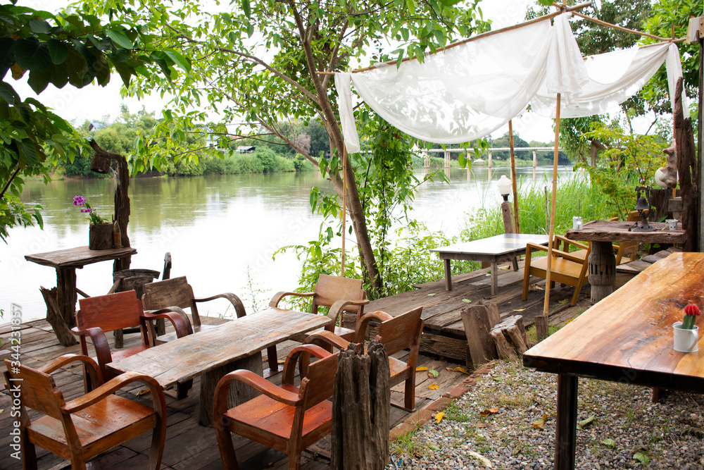 Patio terrace at riverside of Mae Khlong or Meklong river in retro vintage hotel resort for guest use service in evening time at Ratchaburi, Thailand