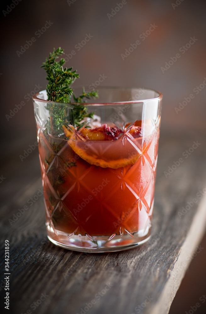 Old-fashioned cocktail with blood oranges and thyme on the rustic background. Selective focus. Shallow depth of field. Old-fashioned cocktail with blood oranges and thyme on the rustic background. Selective focus. Shallow depth of field.