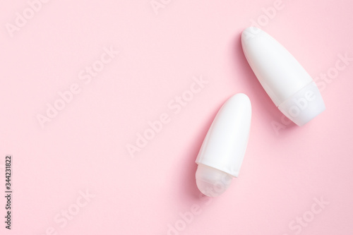 Blank deodorant bottles mockups on pink background. White antiperspirant packaging, female sweat protection product concept