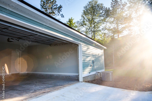 Open two-car garage of a new construction blue house with siding