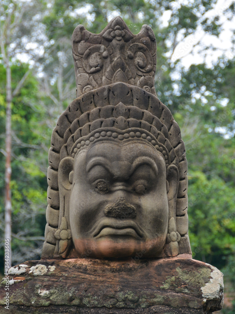 Face of a demon sculpture (asura) in the pathway to Bayon Temple. Angkor Temples in Siem Reap, Cambodia Face of a demon sculpture (asura) in the pathway to Bayon Temple. Angkor Temples in Siem Reap, Cambodia