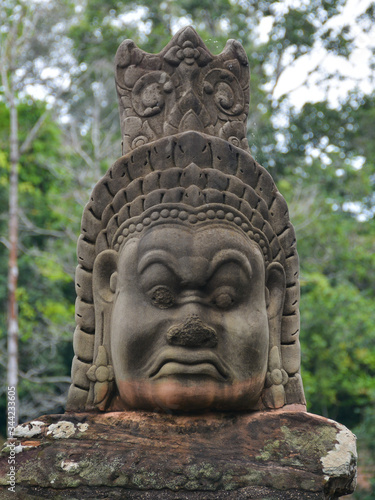 Face of a demon sculpture  asura  in the pathway to Bayon Temple. Angkor Temples in Siem Reap  Cambodia