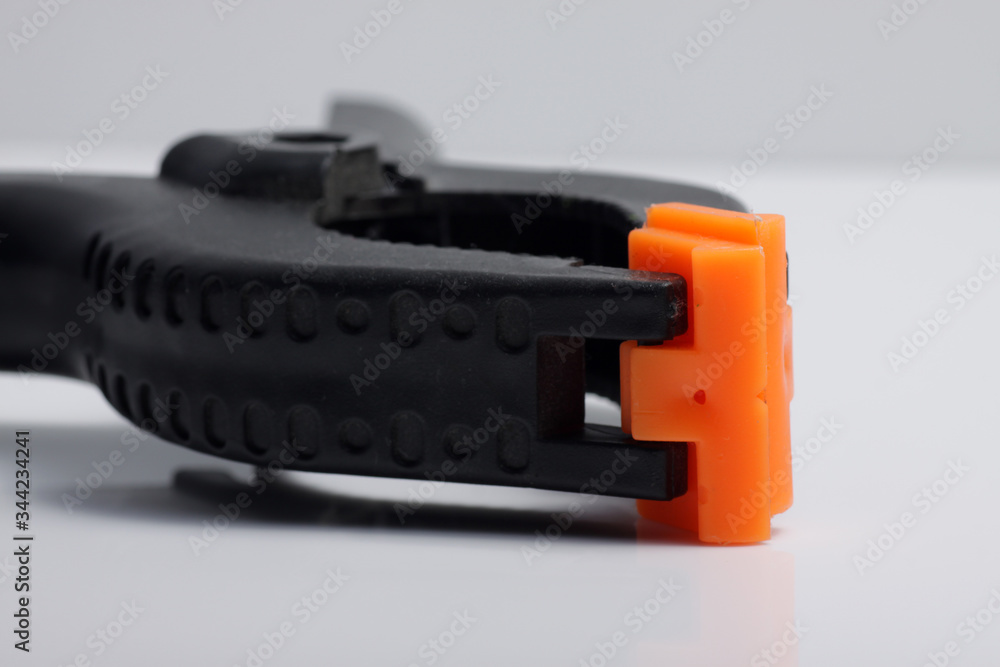 Close up shot of black plastic clamp on a white isolated background