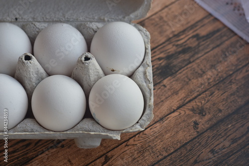 white eggs in a package, eggs lying on a tree, fresh eggs