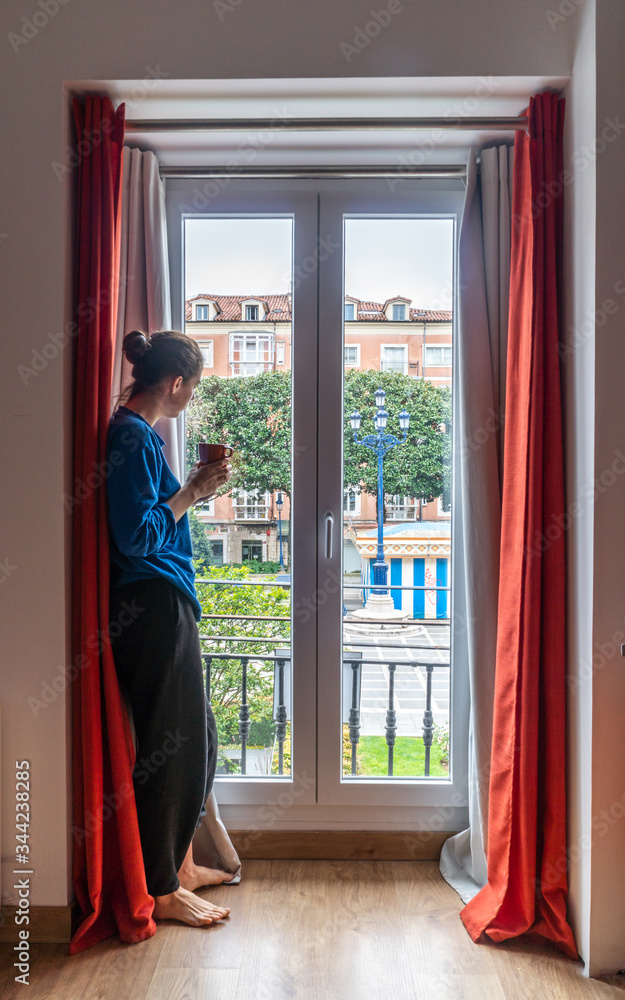 young woman looking out window