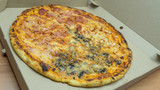Top view of 4 seasons thing pizza with different tastes with salami,cheese and mushrooms .
