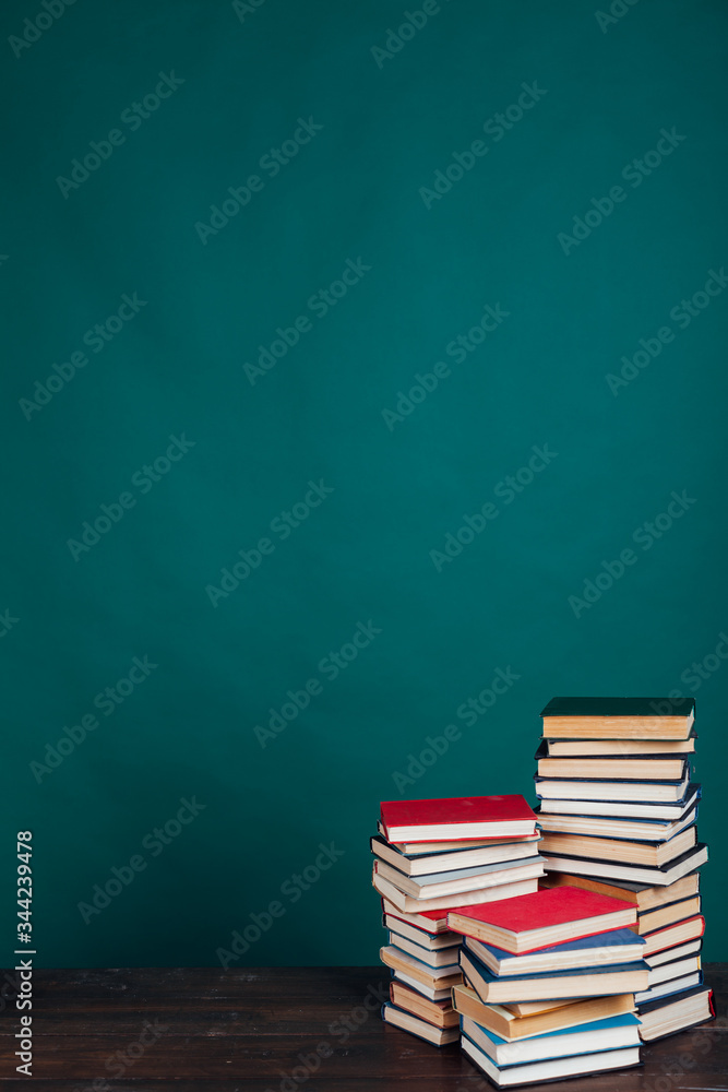 lots of stacks of educational books to teach in the school library on a green background lots of stacks of educational books to teach in the school library on a green background