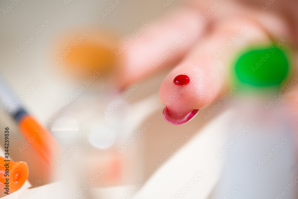 Naklejka premium Close up of asian woman hands using lancet on finger to check blood sugar level by glucose meter, Healthcare medical and check up, diabetes, glycemia concept