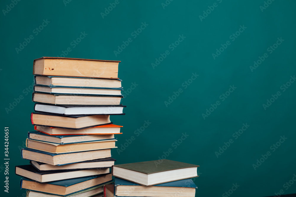 lots of stacks of educational books to teach in the school library on a green background lots of stacks of educational books to teach in the school library on a green background