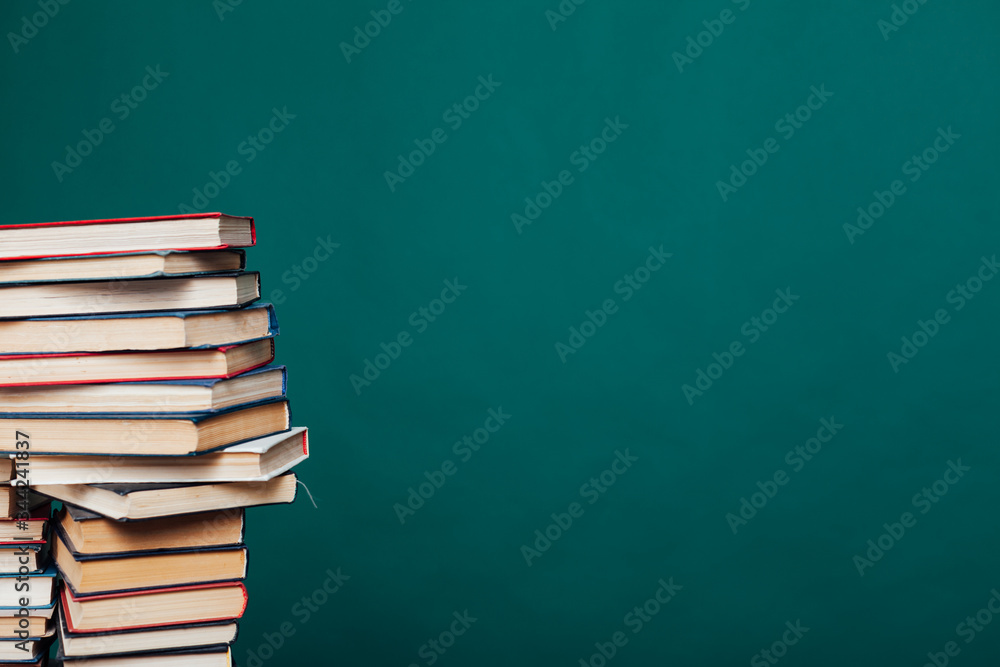 lots of stacks of educational books to teach in the school library on a green background lots of stacks of educational books to teach in the school library on a green background