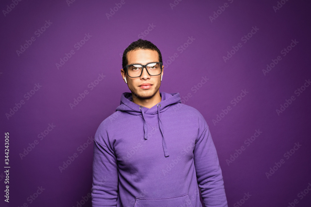 Fototapeta premium Smart intelligent young handsome man wearing eyeglasses standing isolated over purple background.