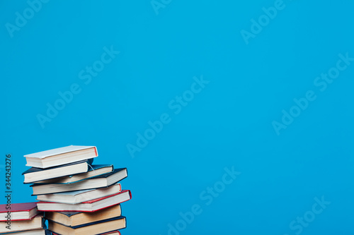 lots of stacks of educational books to teach in the school library on a blue background