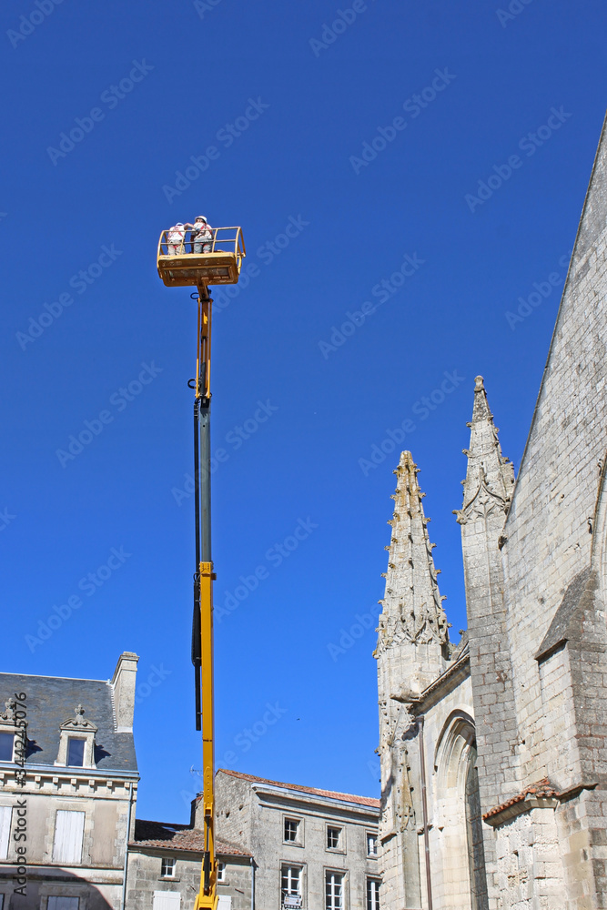 Cherry picker working on Notre Dame Church, Fontenay-le-Comte, France	