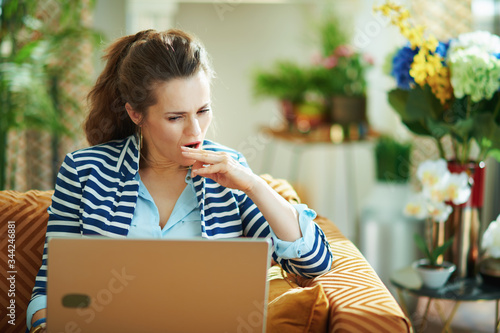 Photo stressed trendy woman with laptop at modern home in sunny day