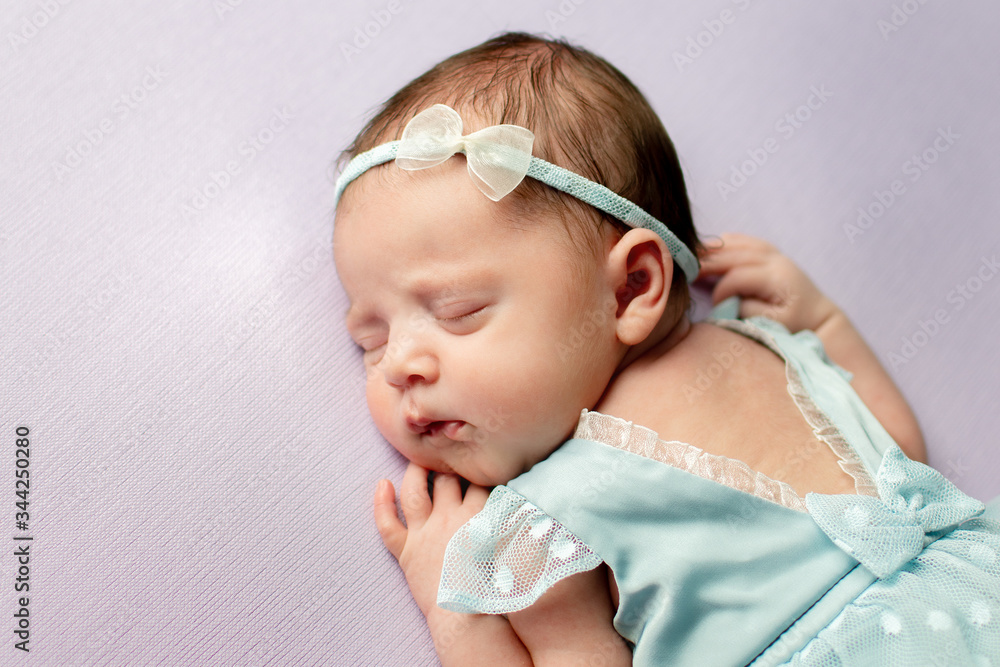 Cute newborn girl in a dress and with an ornament on her head sweetly sleeps Cute newborn girl in a dress and with an ornament on her head sweetly sleeps