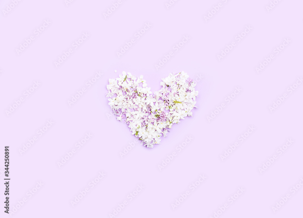 The heart is lined with lilac flowers on a light background. Holiday content.