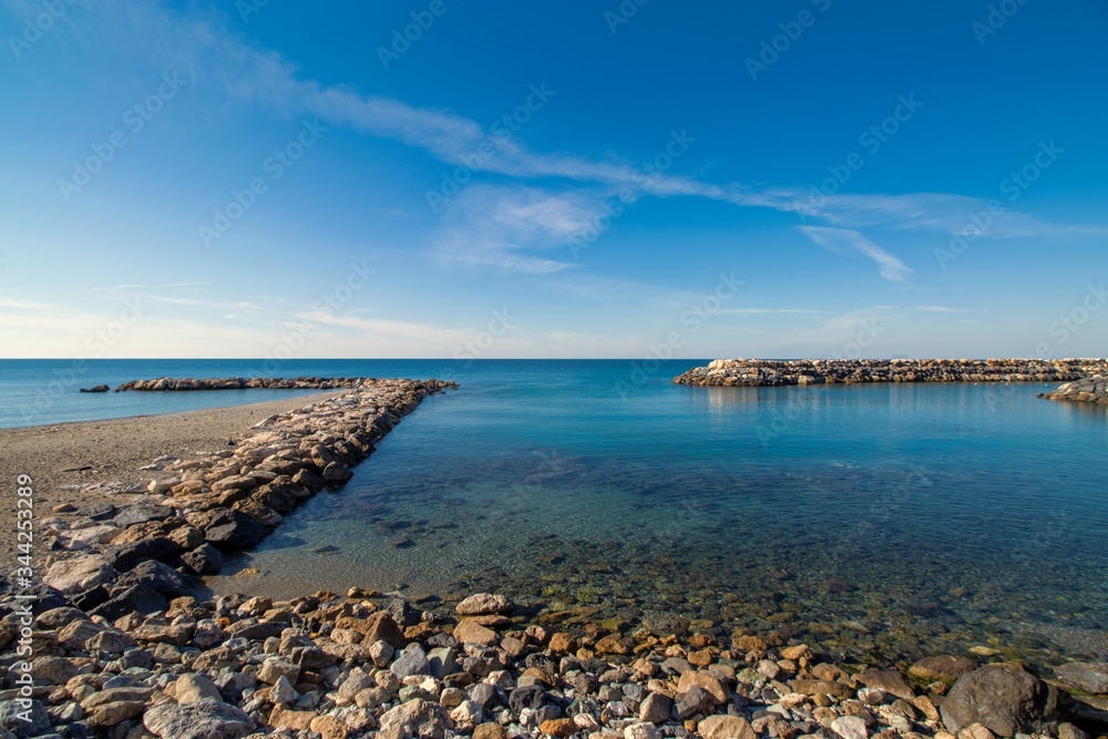 Ingresso porticciolo tra cielo e mare azzurro