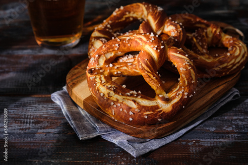 Freshly baked homemade soft pretzel with salt on wooden table. Perfect for Octoberfest.