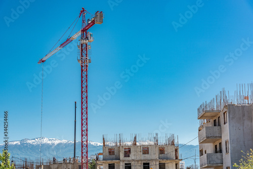 Tower crane, red against the sky and mountains