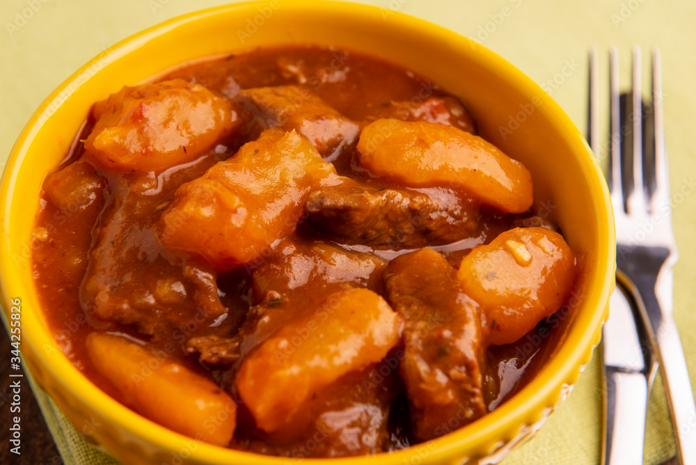 bowl with cooked cassava and meat on wooden table bowl with cooked cassava and meat on wooden table