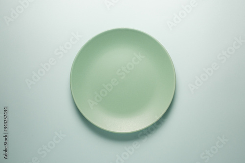 Turquoise empty plate on a light background top view.