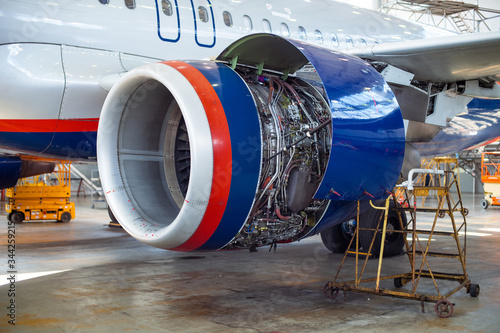 Opened hood of aircraft engine. repairing in the airport hangar