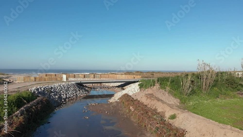 Wallpaper Mural DRONE - view of dune fencing to control wind erosion and encourage dune stability. Stream flowing into the sea at the North Coast Natural Park, The Protected Landscape of Esposende Coast, Portugal. Torontodigital.ca