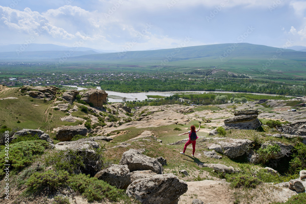 A view of the surrounding landscape at the ancient Uplistsikhe cave town in Georgia.Woman enjoys the mountain scenery