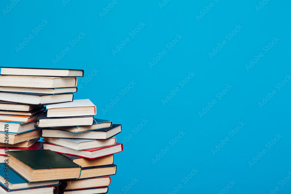 lots of stacks of educational books to teach in the school library on a blue background lots of stacks of educational books to teach in the school library on a blue background