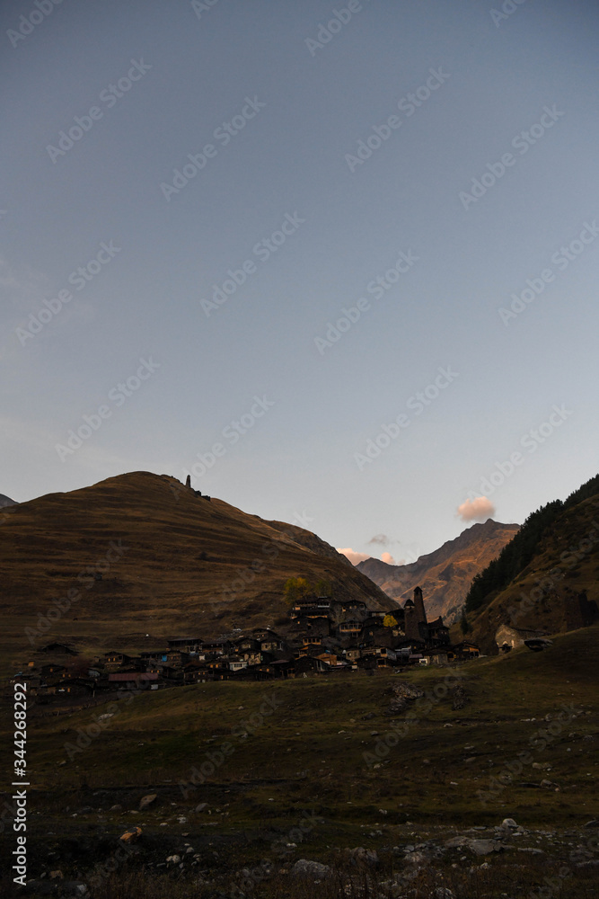 The medieval tower of Kvavlo overlooking the village of Dartlo with mountains in the background.