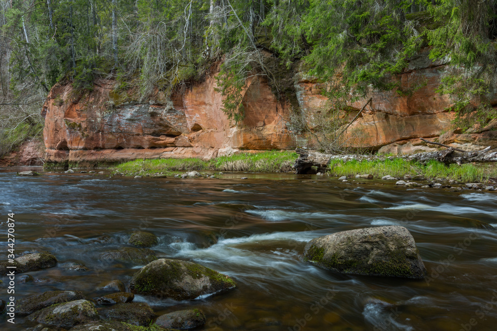 City Cesis, Latvia. River in spring with sandstone cliffs and caves. City Cesis, Latvia. River in spring with sandstone cliffs and caves.
